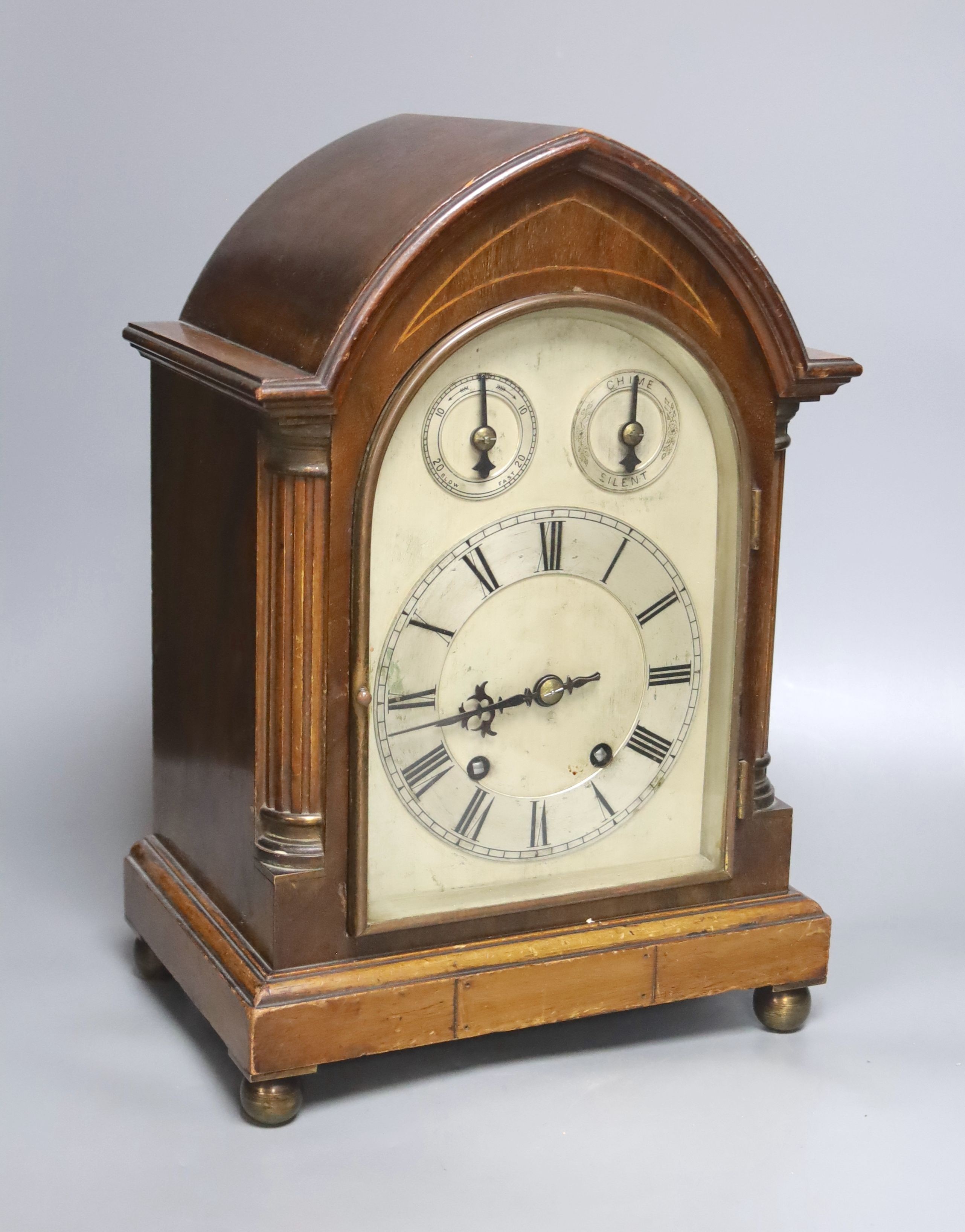 An inlaid mahogany lancet shaped chiming mantel clock with silvered dial, circa 1900. Pendulum and key. 38cm